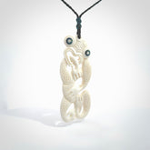 Hand carved bone Tiki pendant. Traditional art hand carved for NZ Pacific. Bone Tiki necklace with Paua Shell eyes. Delivered with Express Courier. Provided with adjustable cords and packaged in a woven kete pouch.